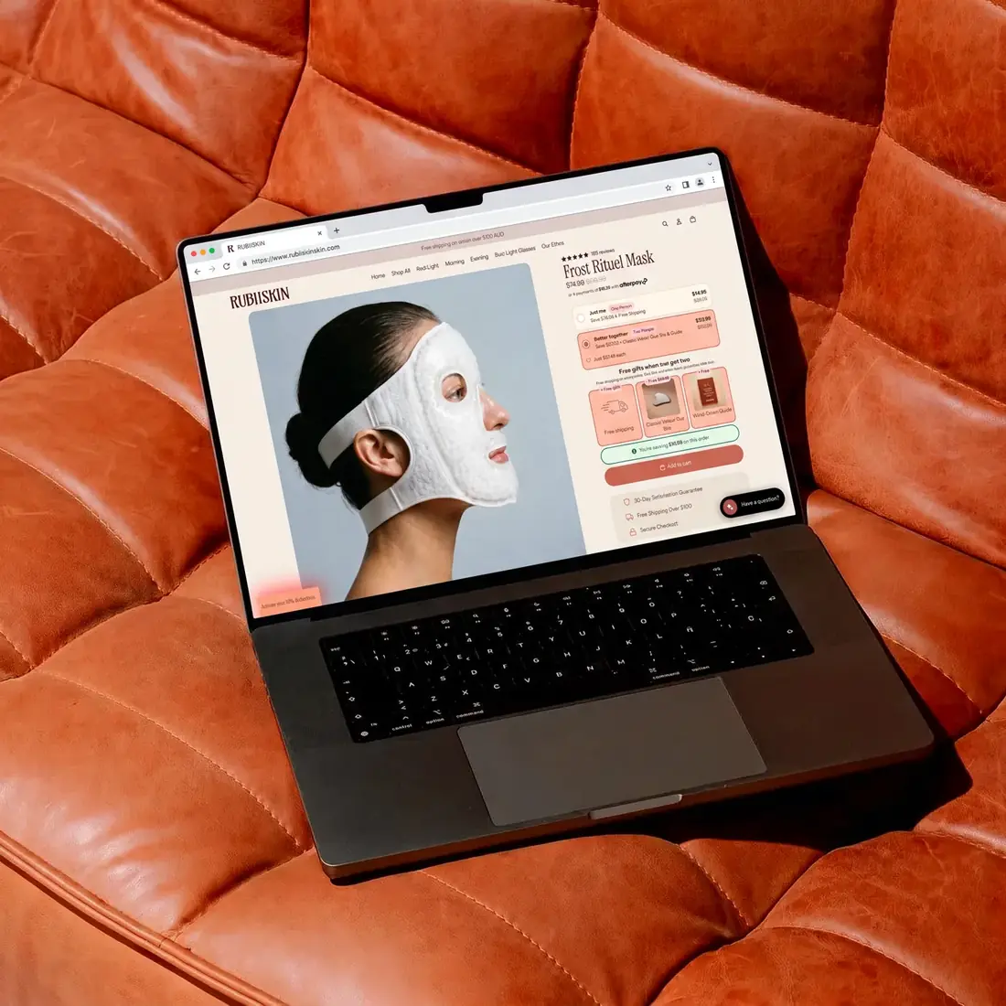 Rubiiskin product page on a laptop on a tan leather sofa